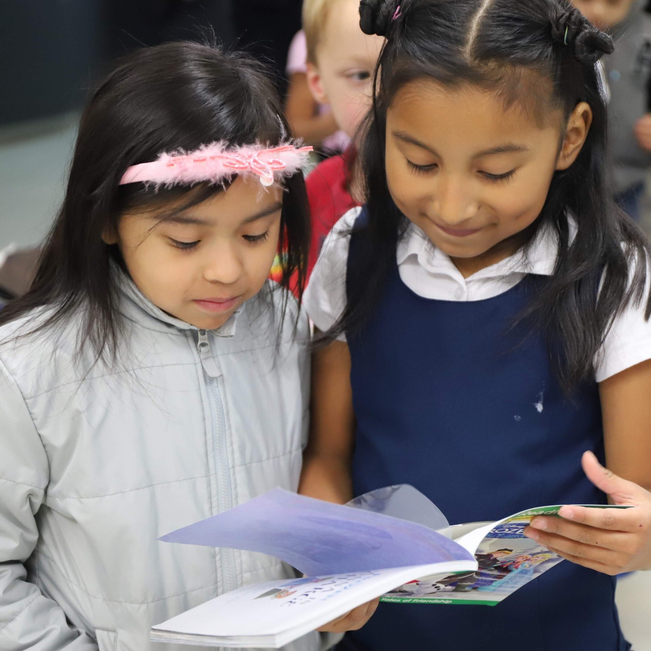 Two girls reading their books from Book'em together.