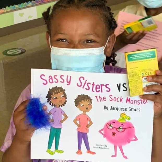 Girl in mask holds book featuring Black characters